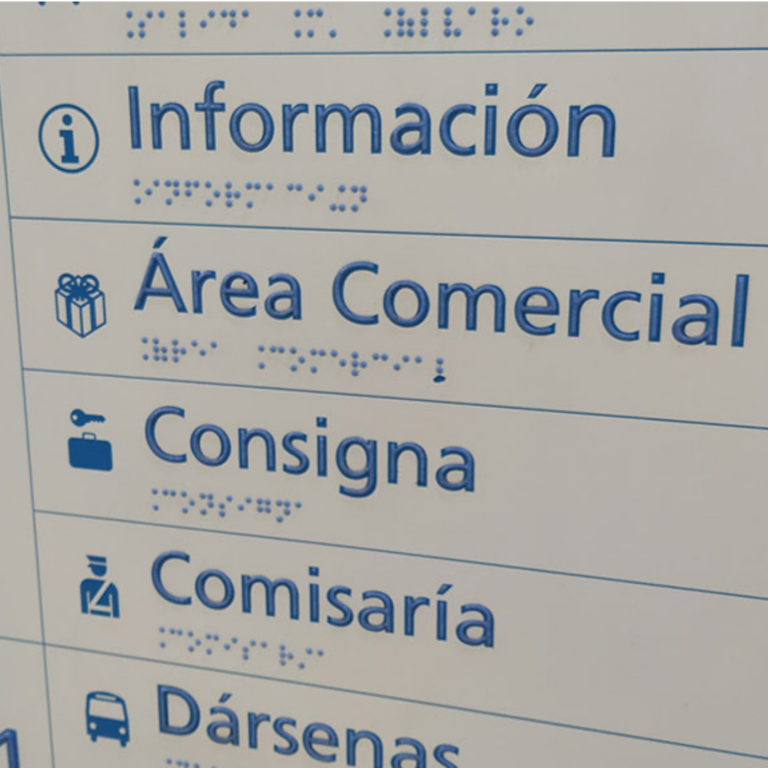 Cartel con indicaciones con letras en braille abajo